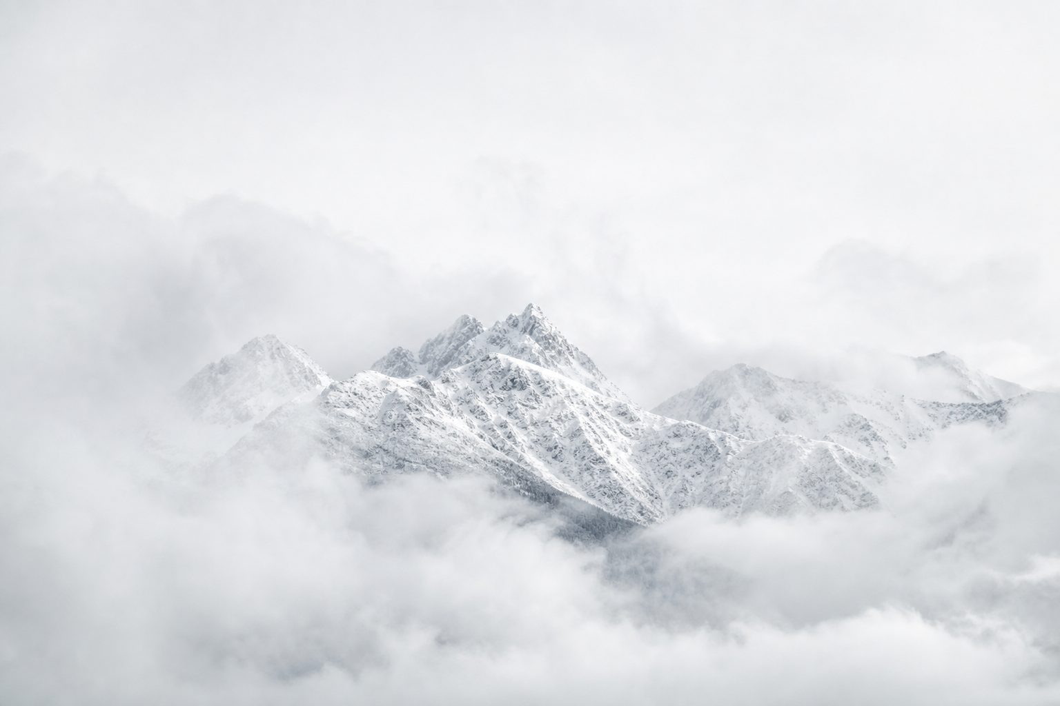 Verschneite Berggipfel im Nebel